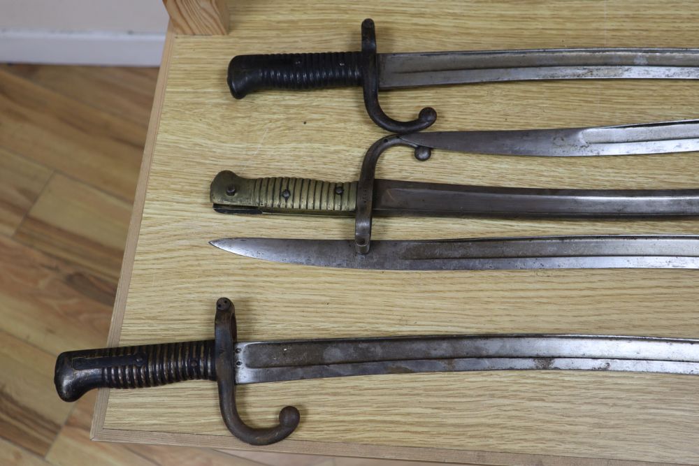 Six bayonets and two axes, largest 99cm